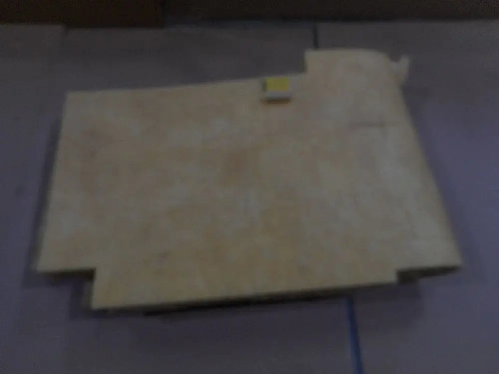 Isoliermaterial in heller Farbe, flächig oder rollenförmig, mit einem kleinen gelben Rechteck, auf einer ebenen Unterlage. Produkt von Remeha, zur Isolierung von Kesseln gedacht.